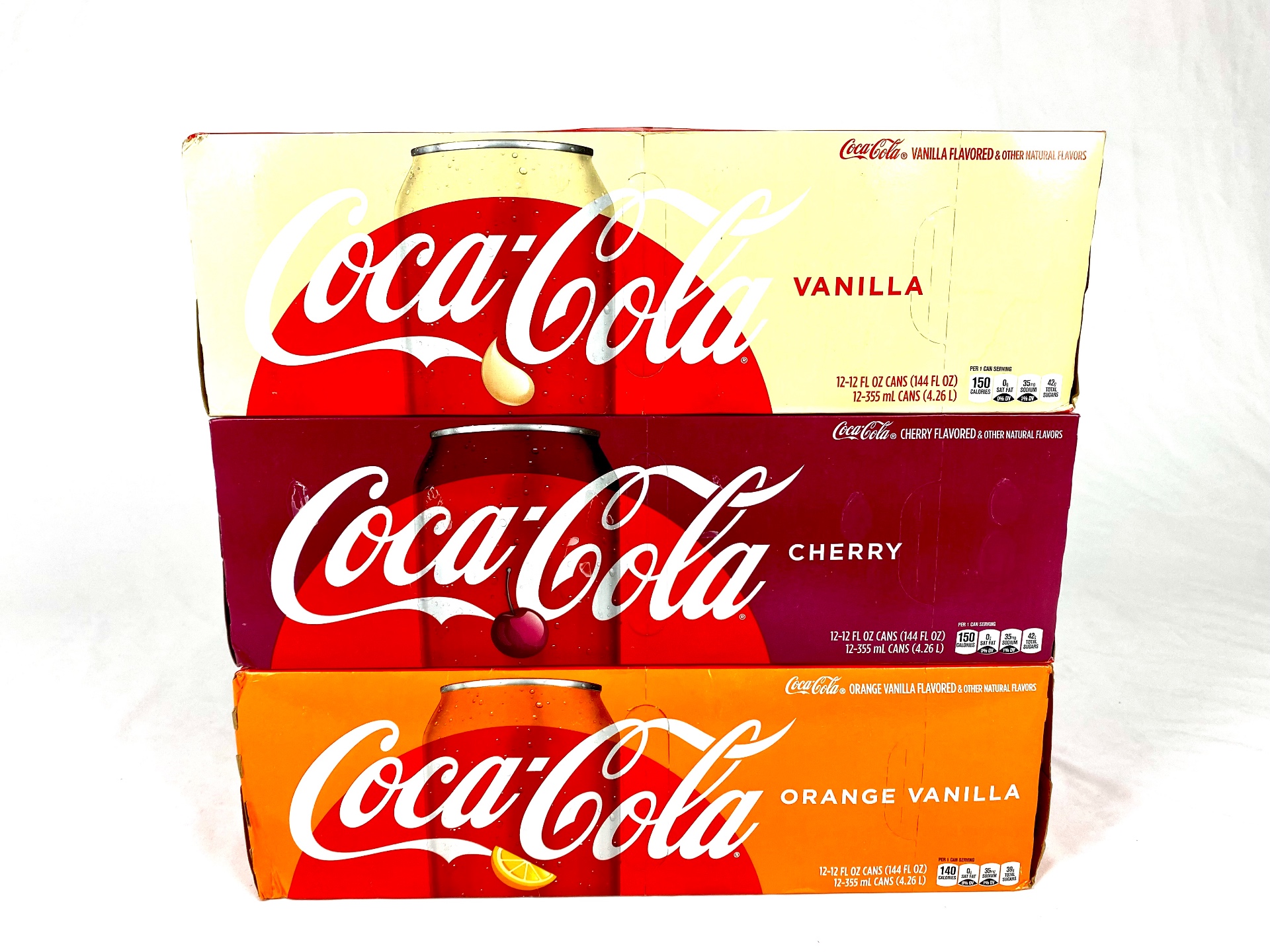 Gestapelte Coca-Cola-Kartons in verschiedenen Sorten